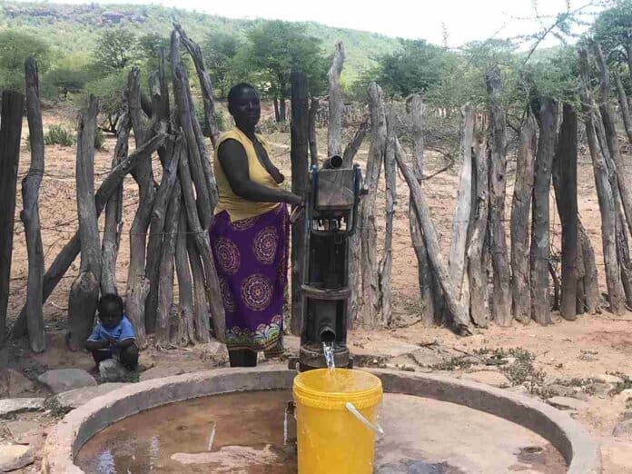 Hwange District Resident Draws Water From A Wildlife Revenue Supported Borehole As Her Child Looks On (1) 11zon Where Villagers Are Eternally Grateful for International Hunting Benefits