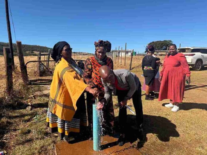 MEC Nonceba Kontsiwe is joined by the chairperson on the local spring water project, Mzuxolile Griffiths and Instika Yethu Municipality Mayor Khanyisa Mdleleni during the official handover of spring water project in Chamama Forest village